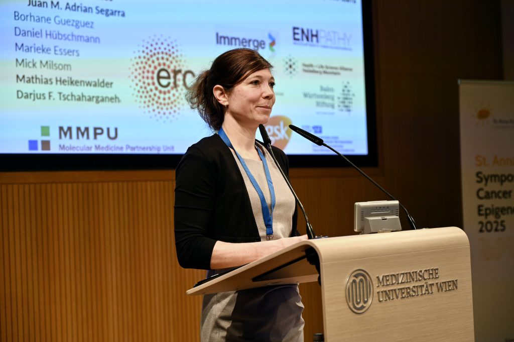 The scientist Judith Zaugg stands behind a speakers desk presenting her research