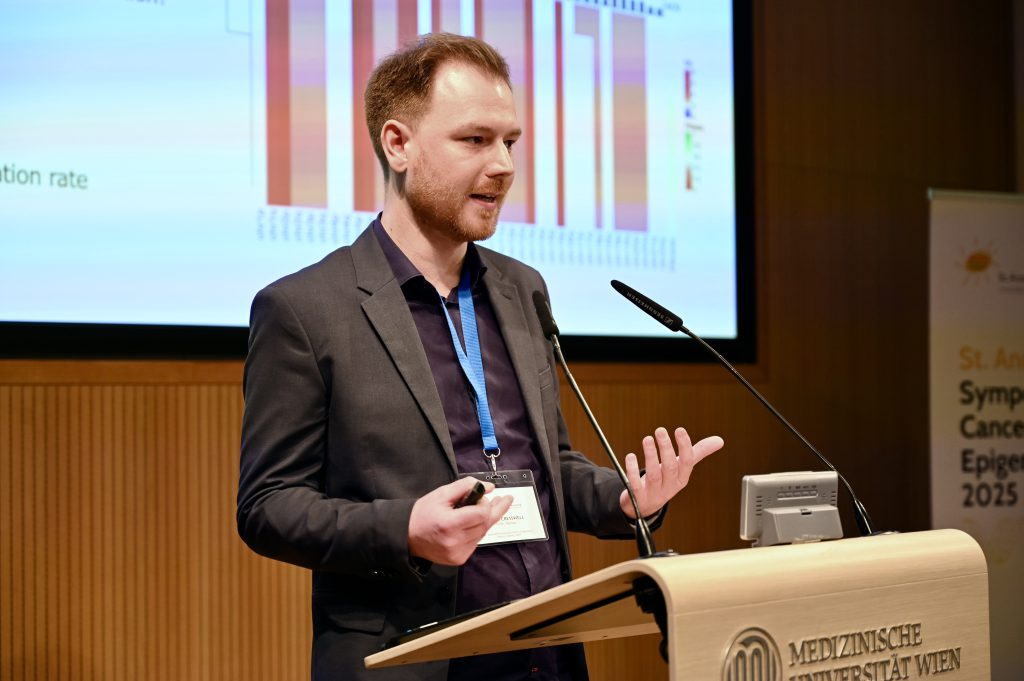 The scientist George Cresswell stands behind a speakers desk presenting his research