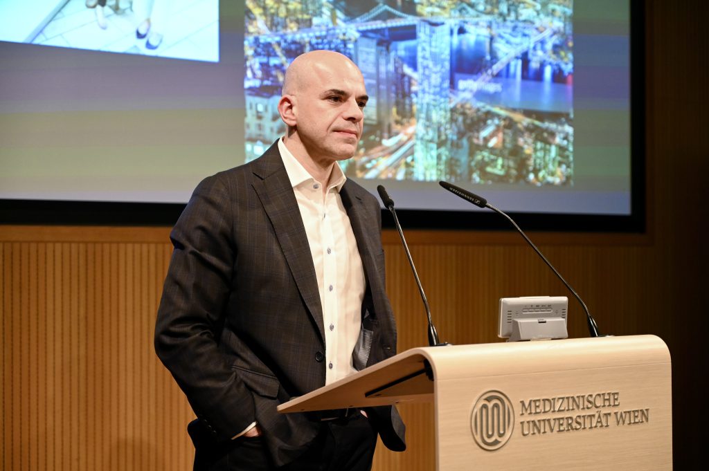 The scientist Iannis Aifantis stands behind a speakers desk presenting his research